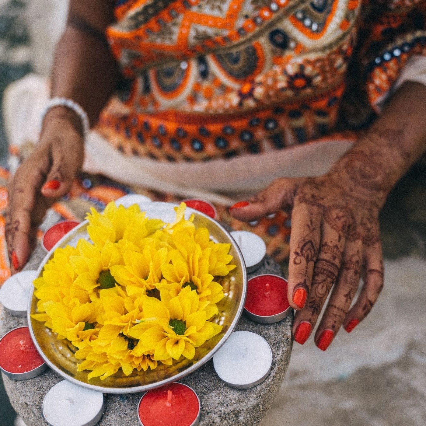 woman holding flowers and candles for Akshaya Tritiya