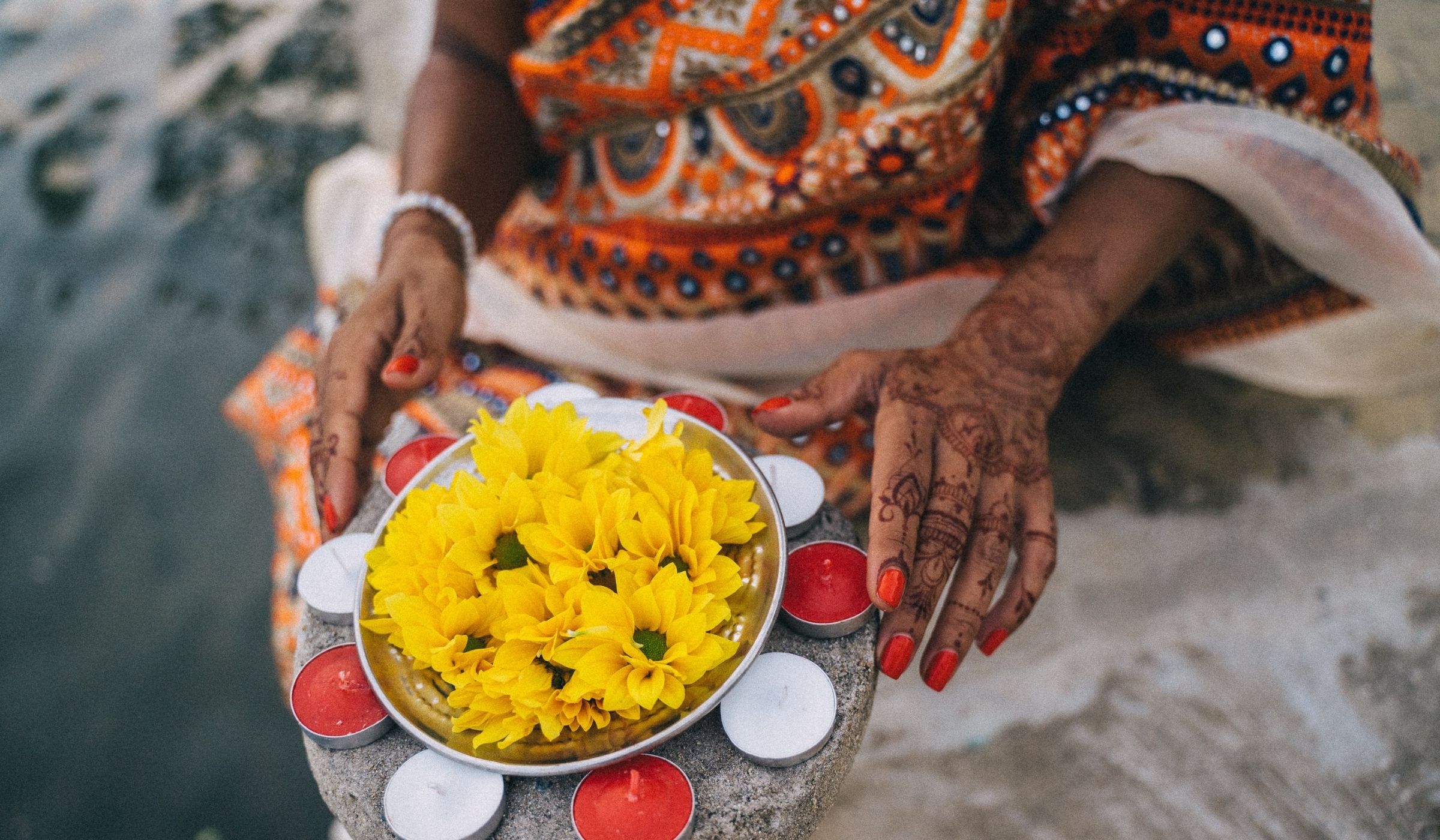 woman holding flowers and candles for Akshaya Tritiya